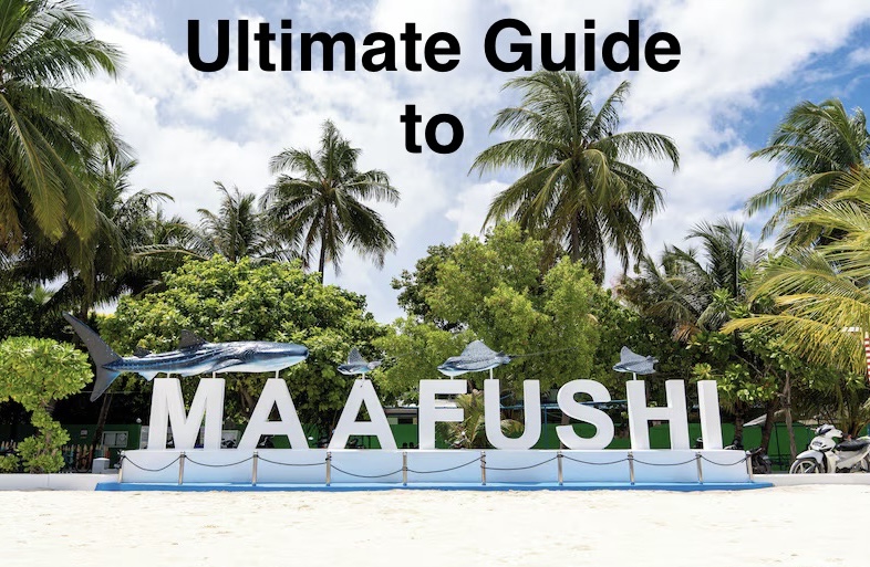 the welcome sign at Maafushi harbour with  models of a whale shark and manta ray above it