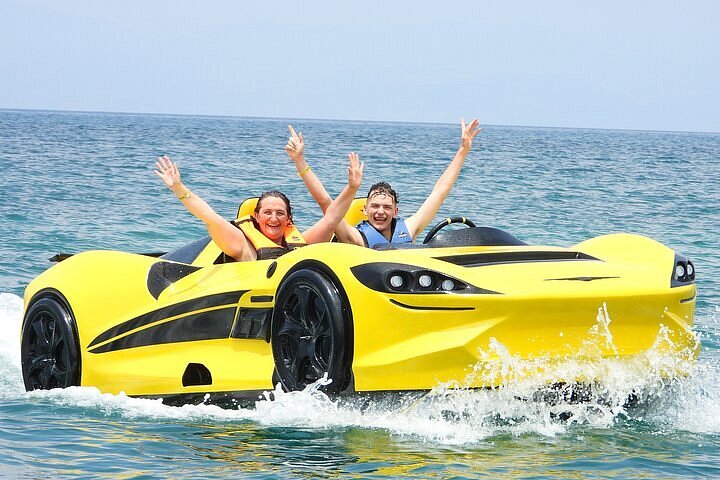yellow jet car with two tourists waving